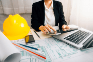 midshot office worker at desk on laptop with helmet