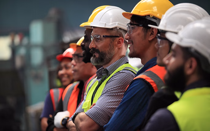 seven construction workers smiling and looking to the side