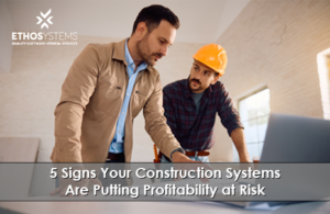 Construction project manager and superintendent reviewing job costs on a laptop to prevent profitability risk