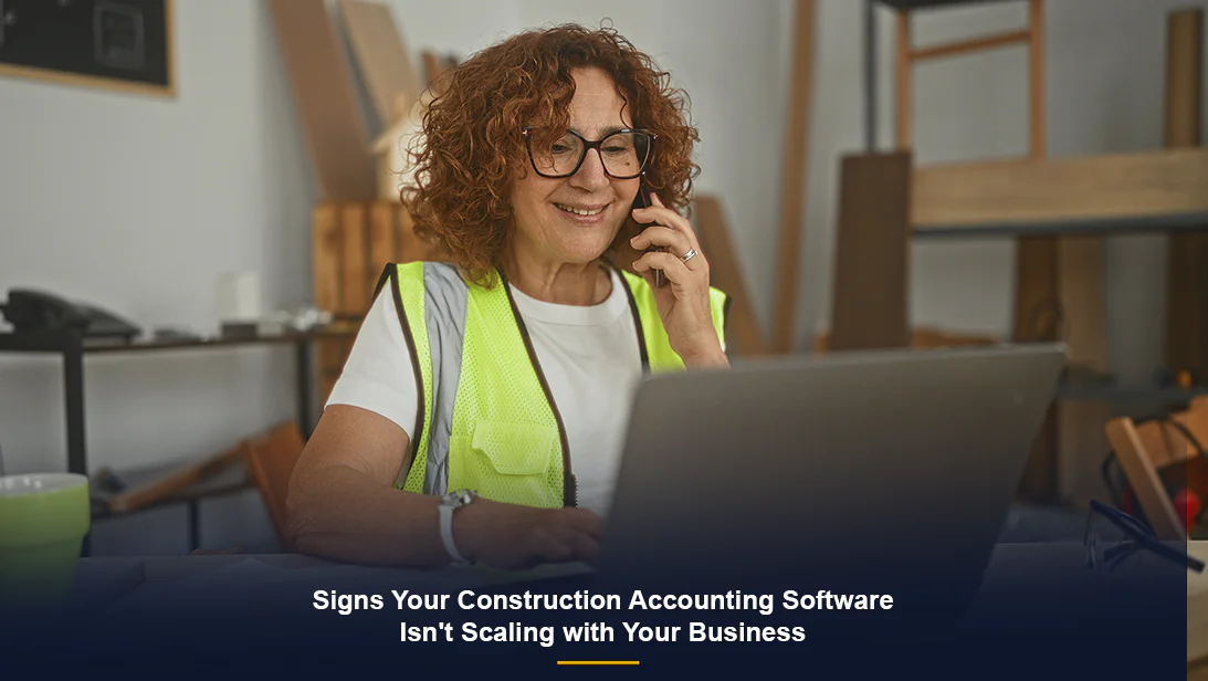 Construction professional using laptop to manage job data with construction accounting software.